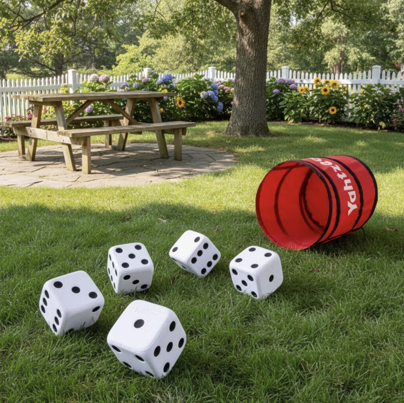 Huge Yahtzee giant dice and pop-up rolling bucket set up on a backyard lawn